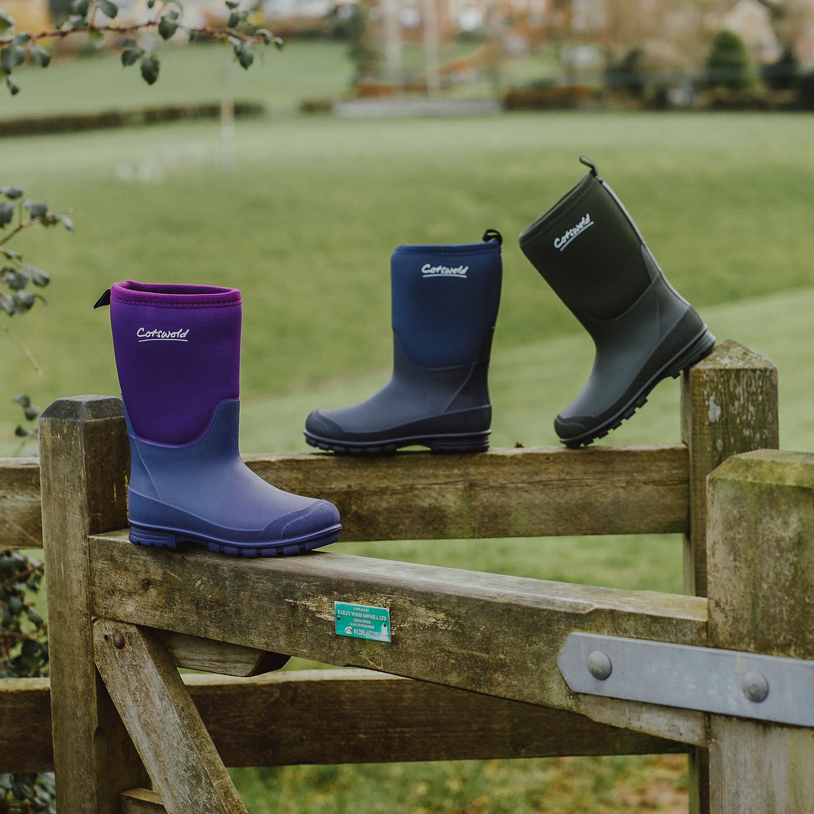 A selection of 3 Cotswold children's Hilly Wellingtons on a gate